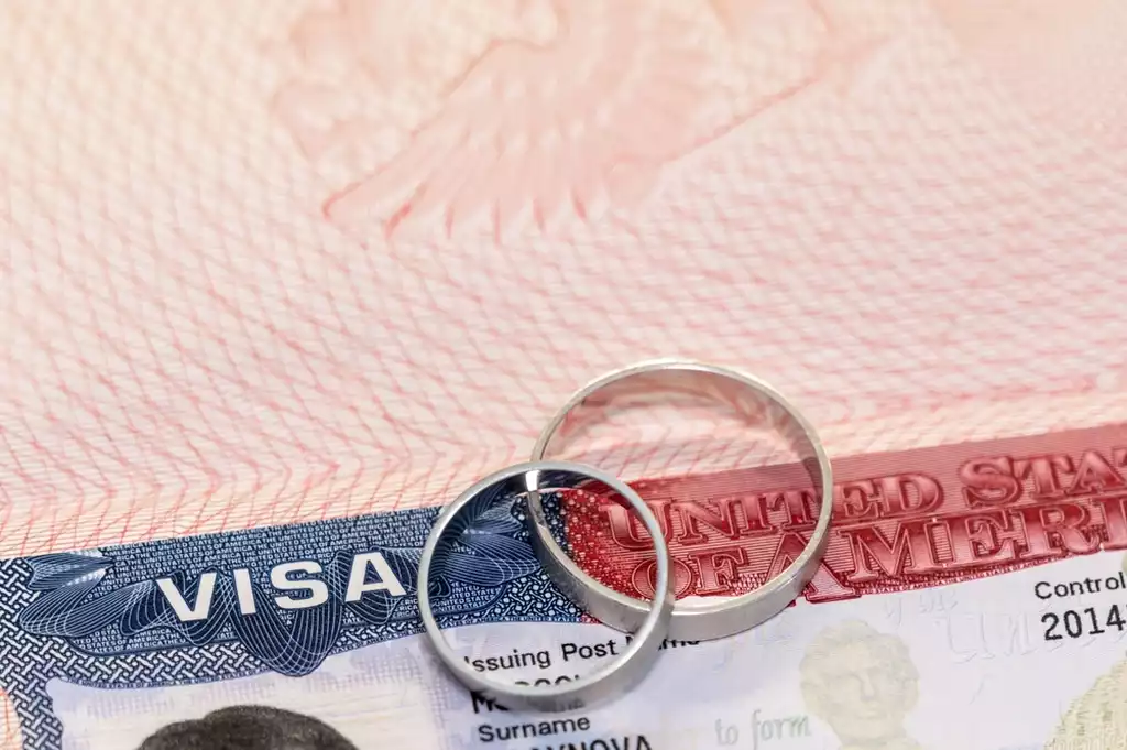 Close up of two wedding rings on top of a USA visa